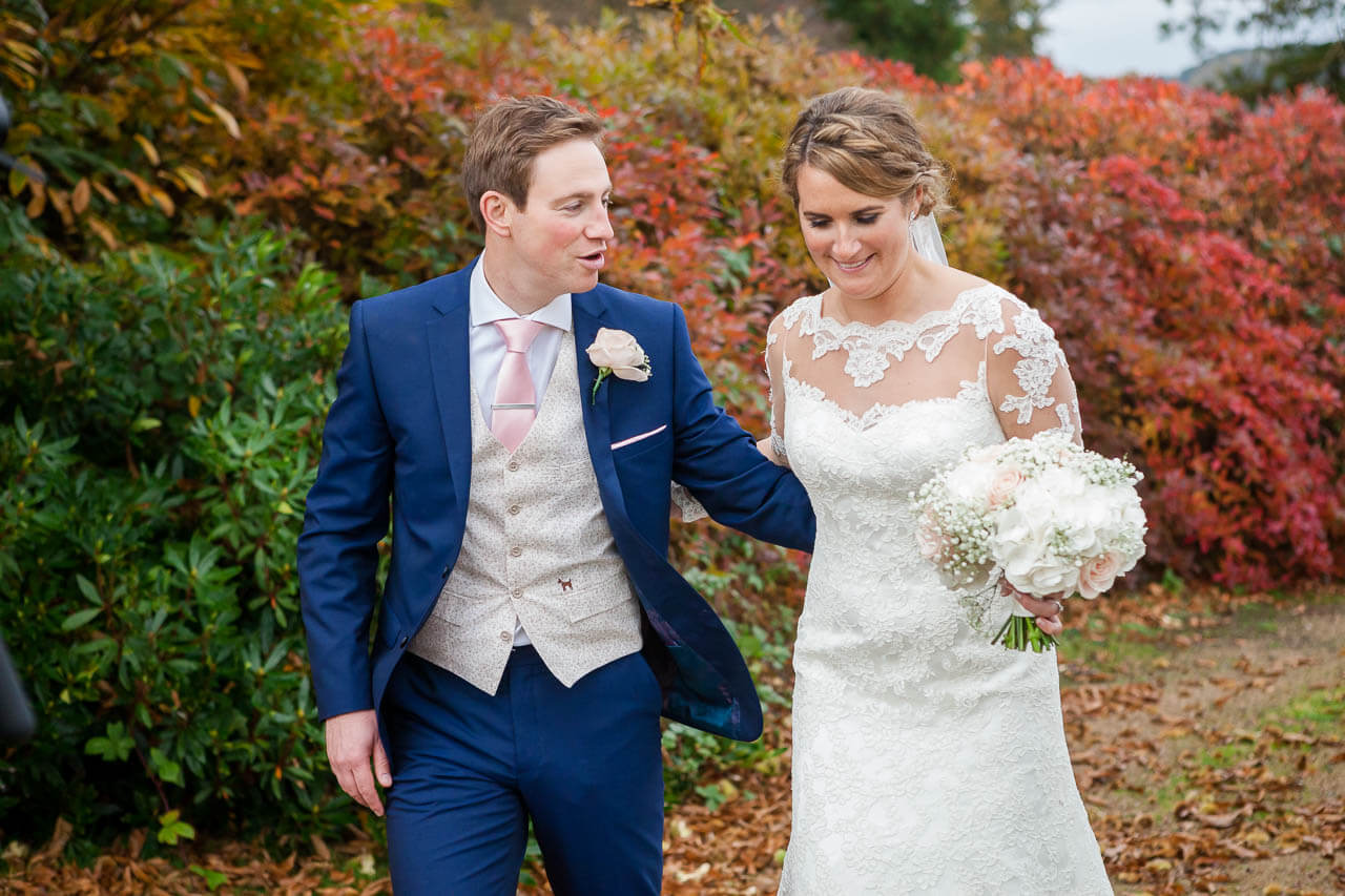 groom leading bride along pathway