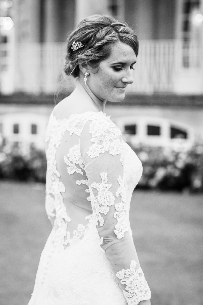 bride looks down to her side with photo taken from behind