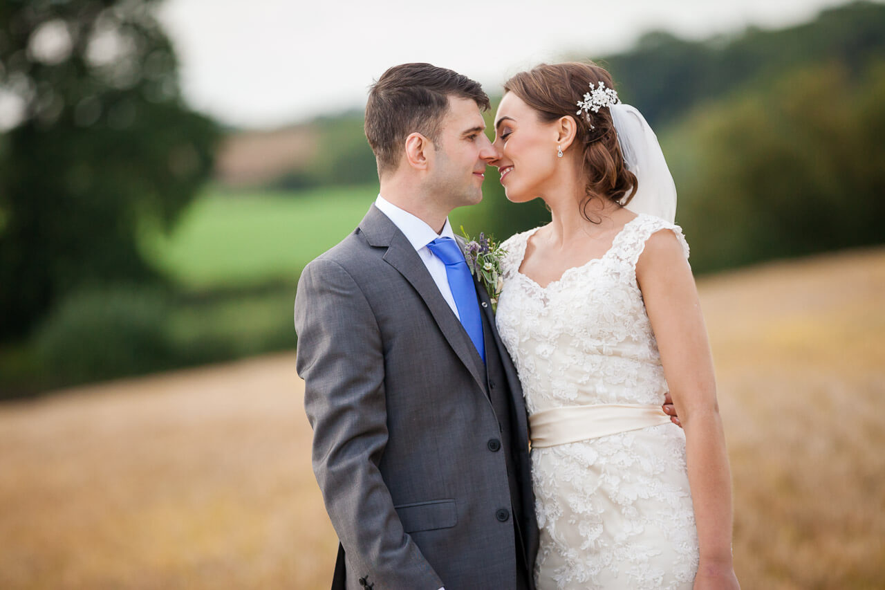 bride and groom bringing faces in to kiss