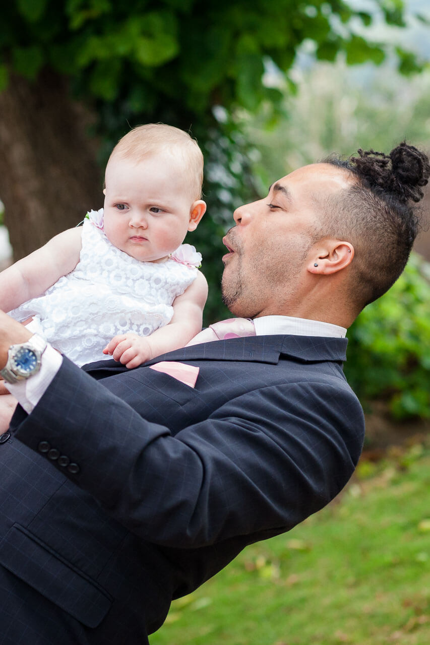 man carrying baby making funny face