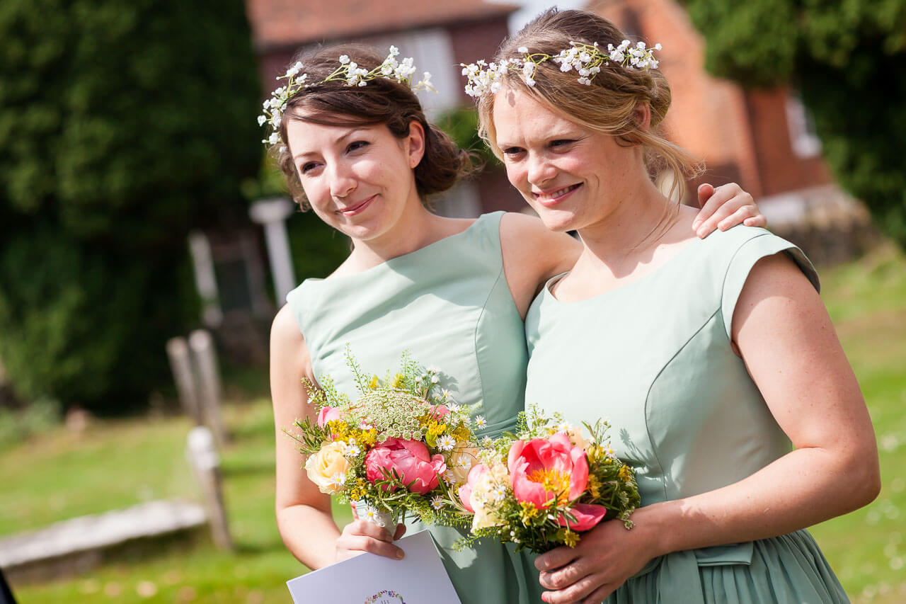 two bridesmaids looking emotional as bride leaves