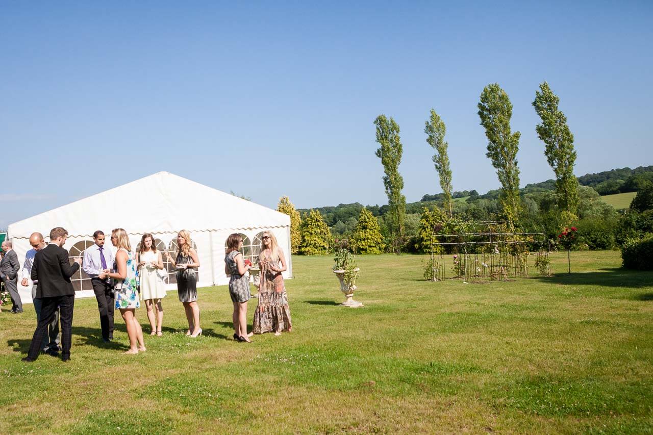 field and marquee with trees and garden in background