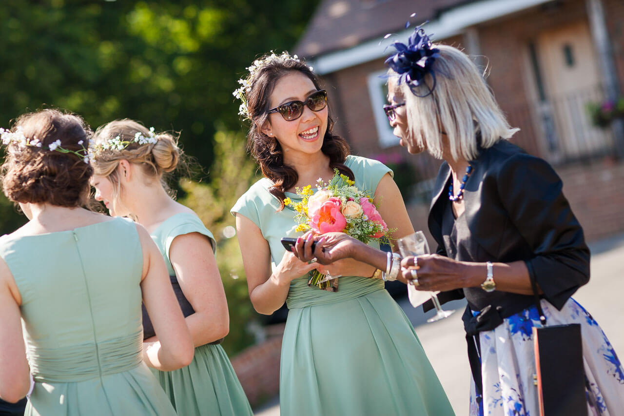 three guests smiling and laughing at reception drinks
