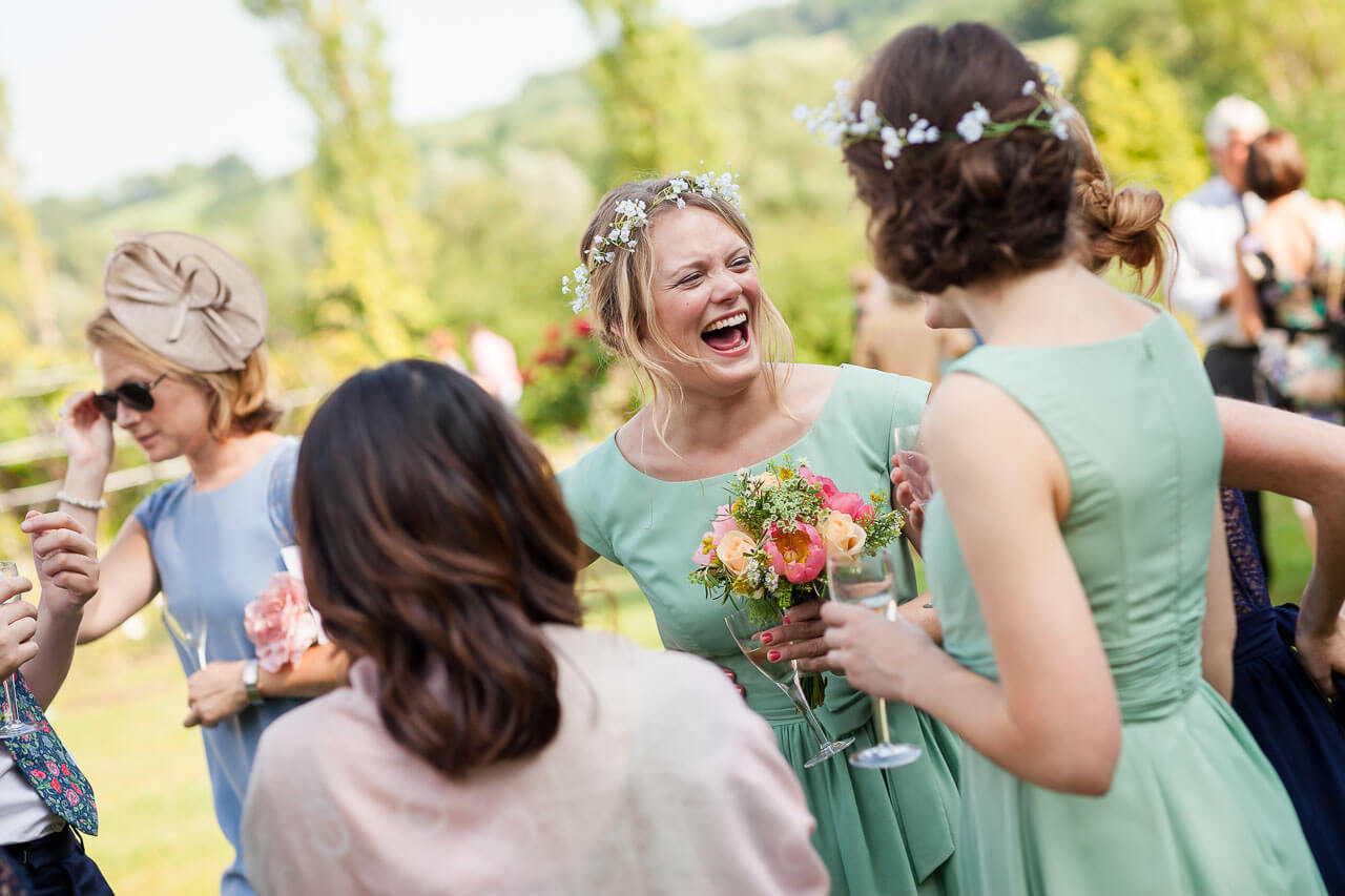 bridesmaid laughing and looking at guest