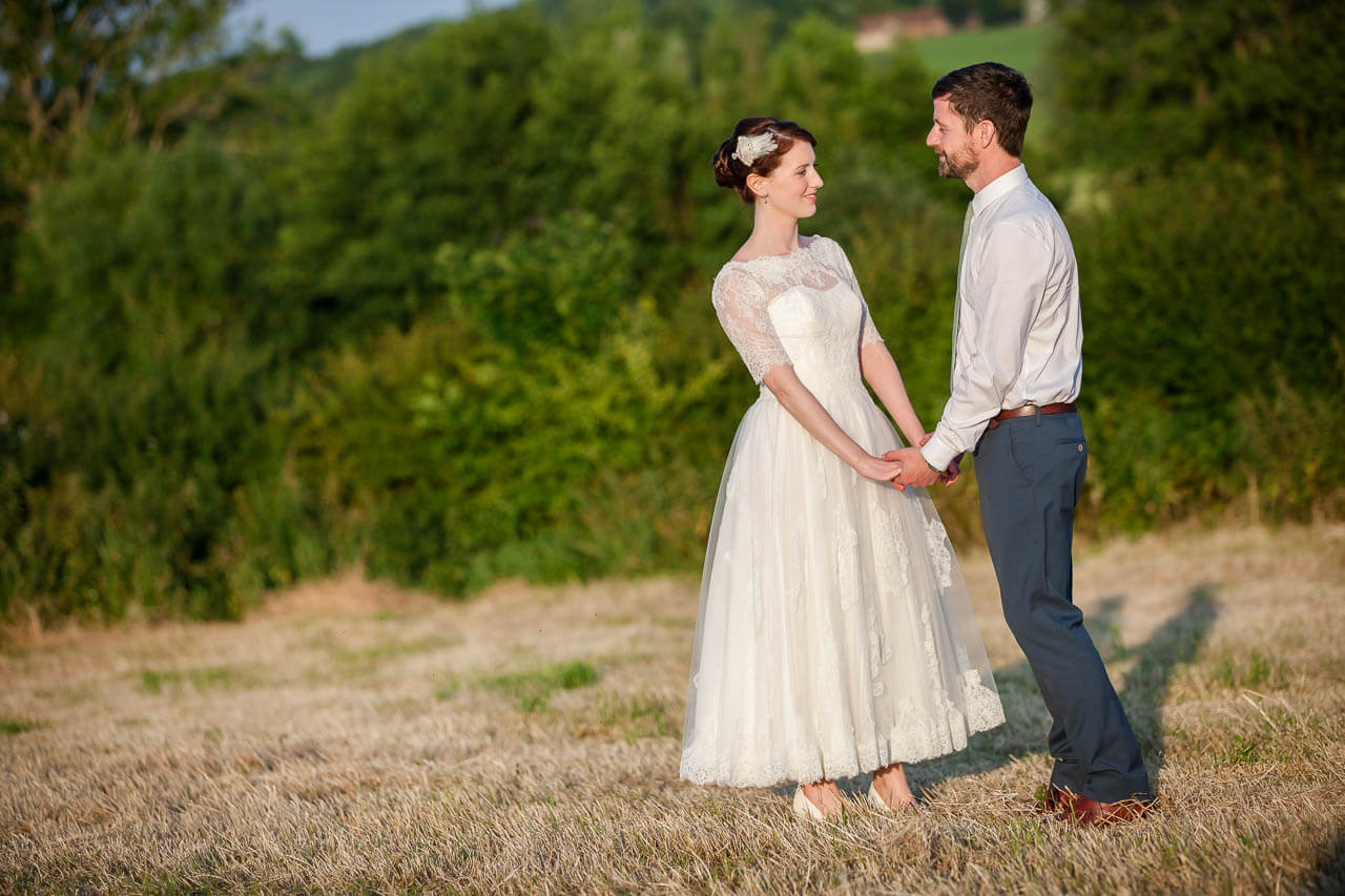 bride and groom holding hands looking at each other