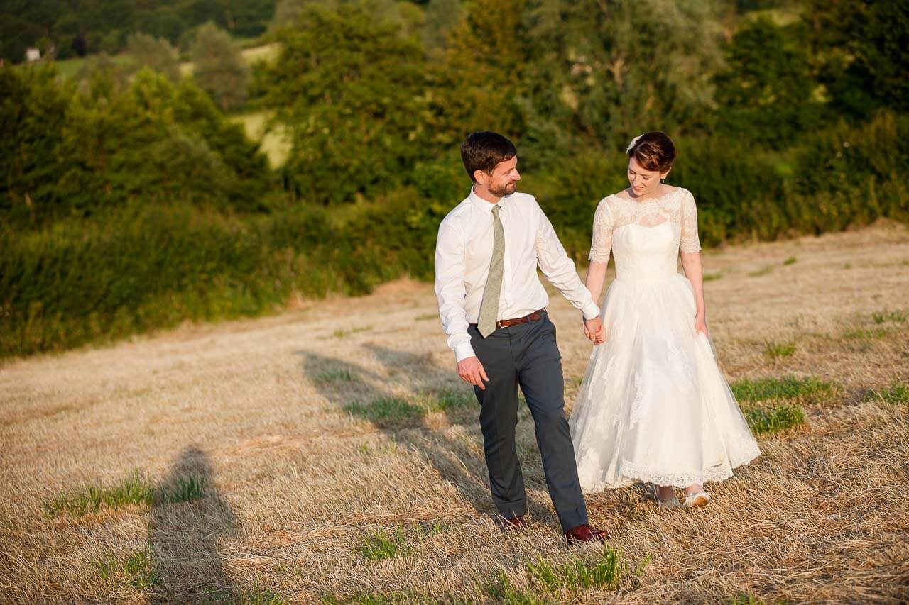 bride and groom walking towards camera during golden hour