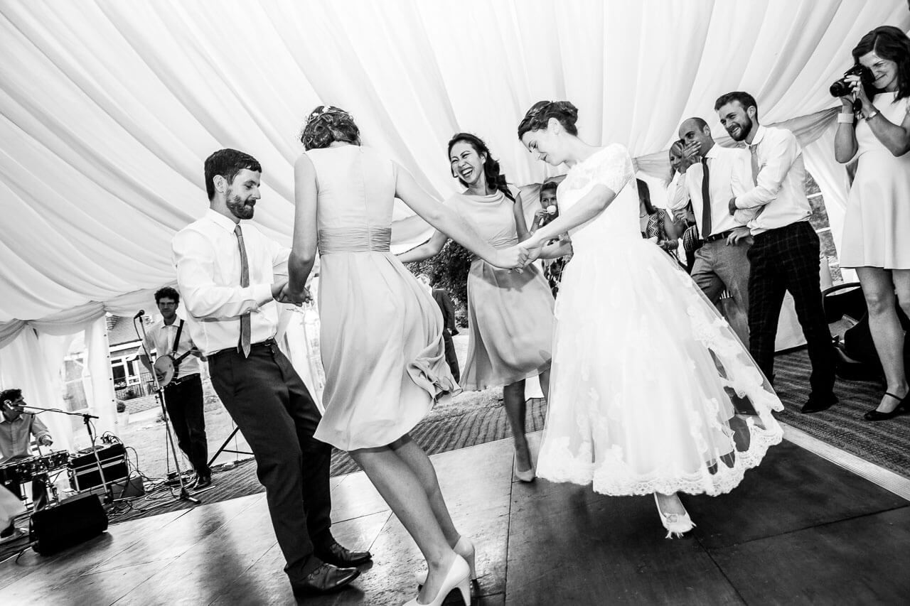 guests in a circle all dancing to live band