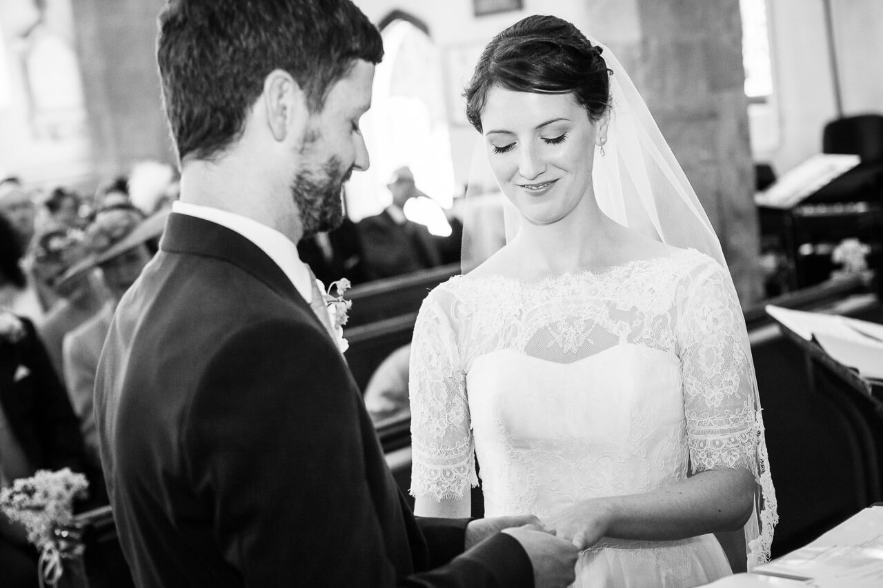 groom and bride placing rings on fingers
