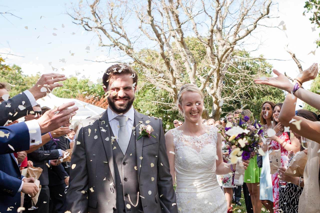 bride and groom walking through confetti