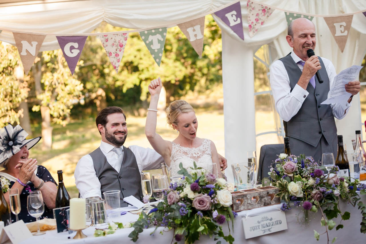 couple react with smiles listening to fathers speech