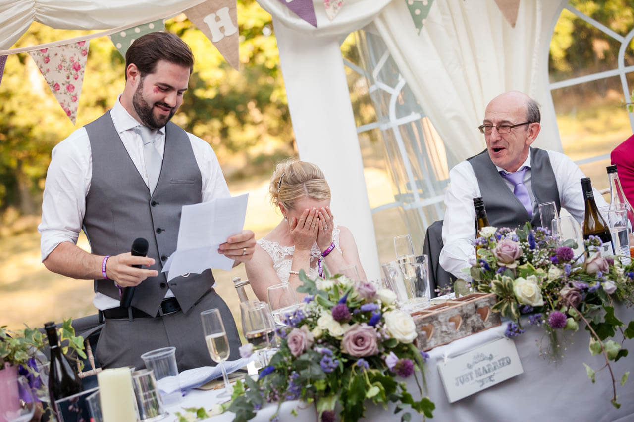 bride with heads in hands while listening to speeches