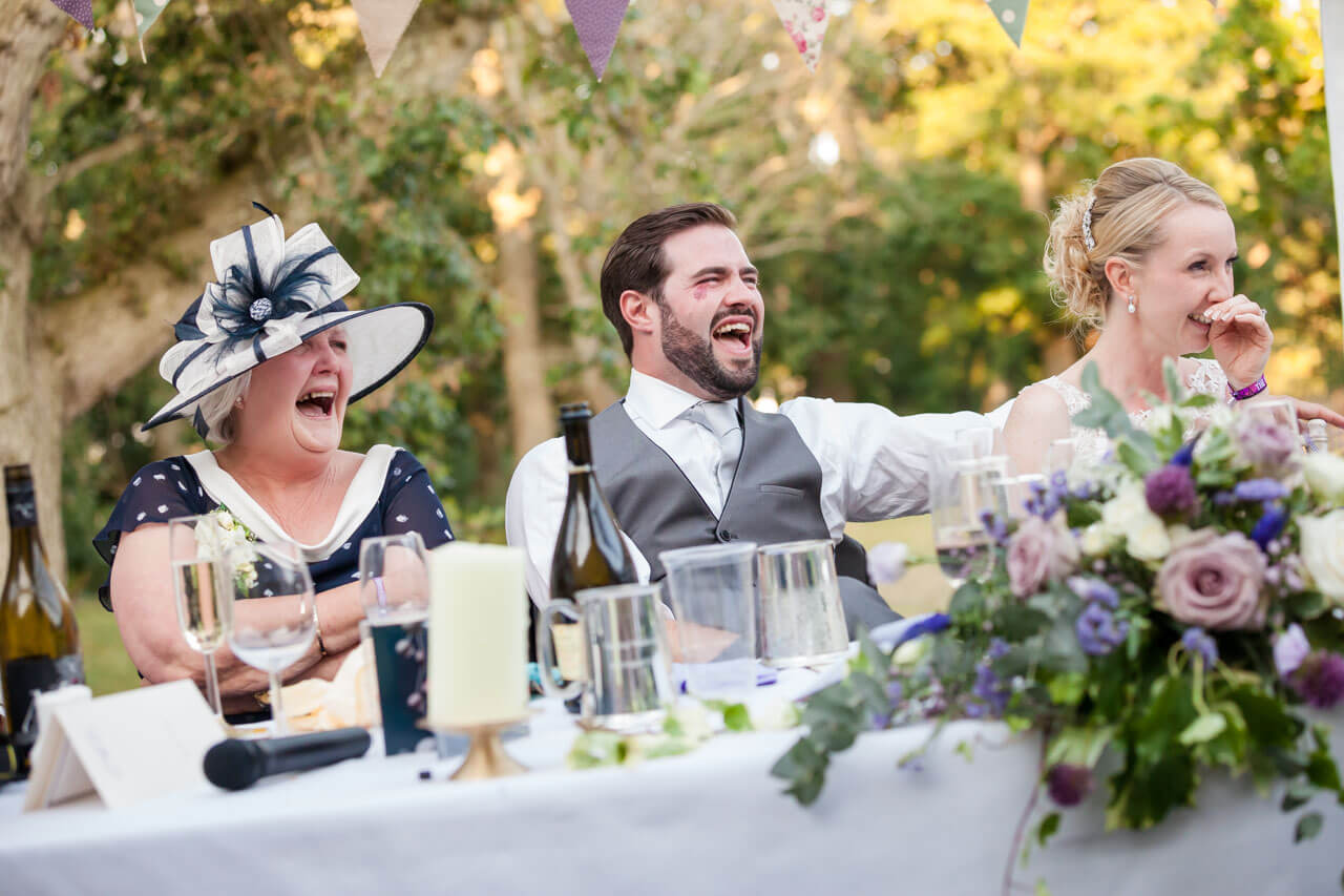 groom with big laughter while listening to speeches