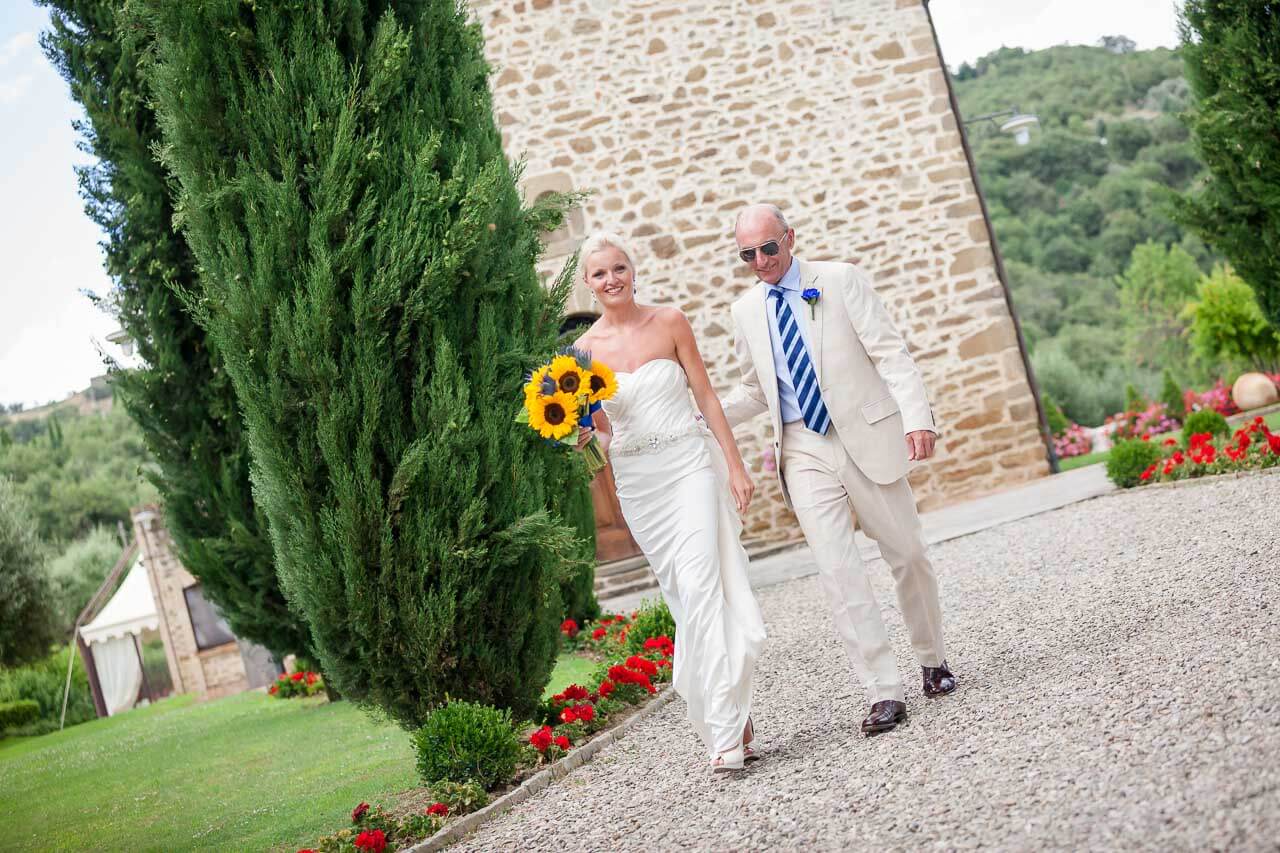 bride and father walking down villa driveway