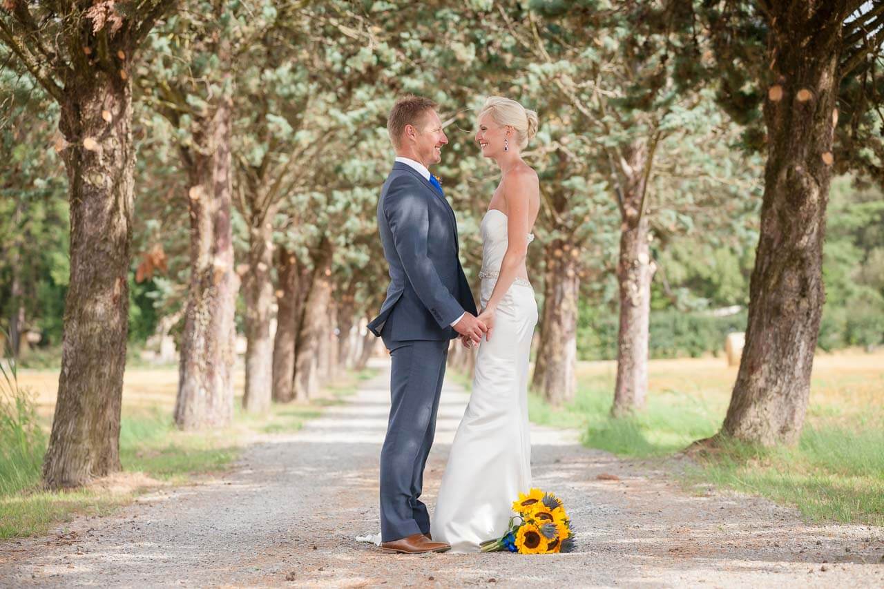 bride and groom holding hands looking at each other standing in beautiful Tuscan lane