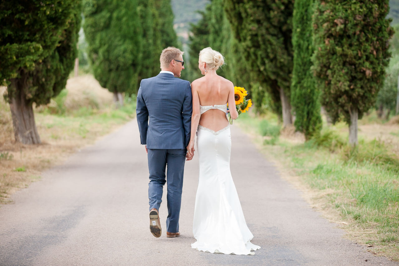 bride and groom walking away from camera looking at each other