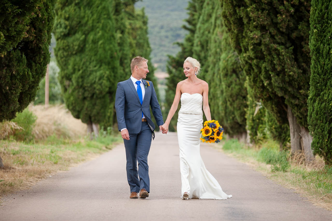 bride and groom walk towards camera holding hands