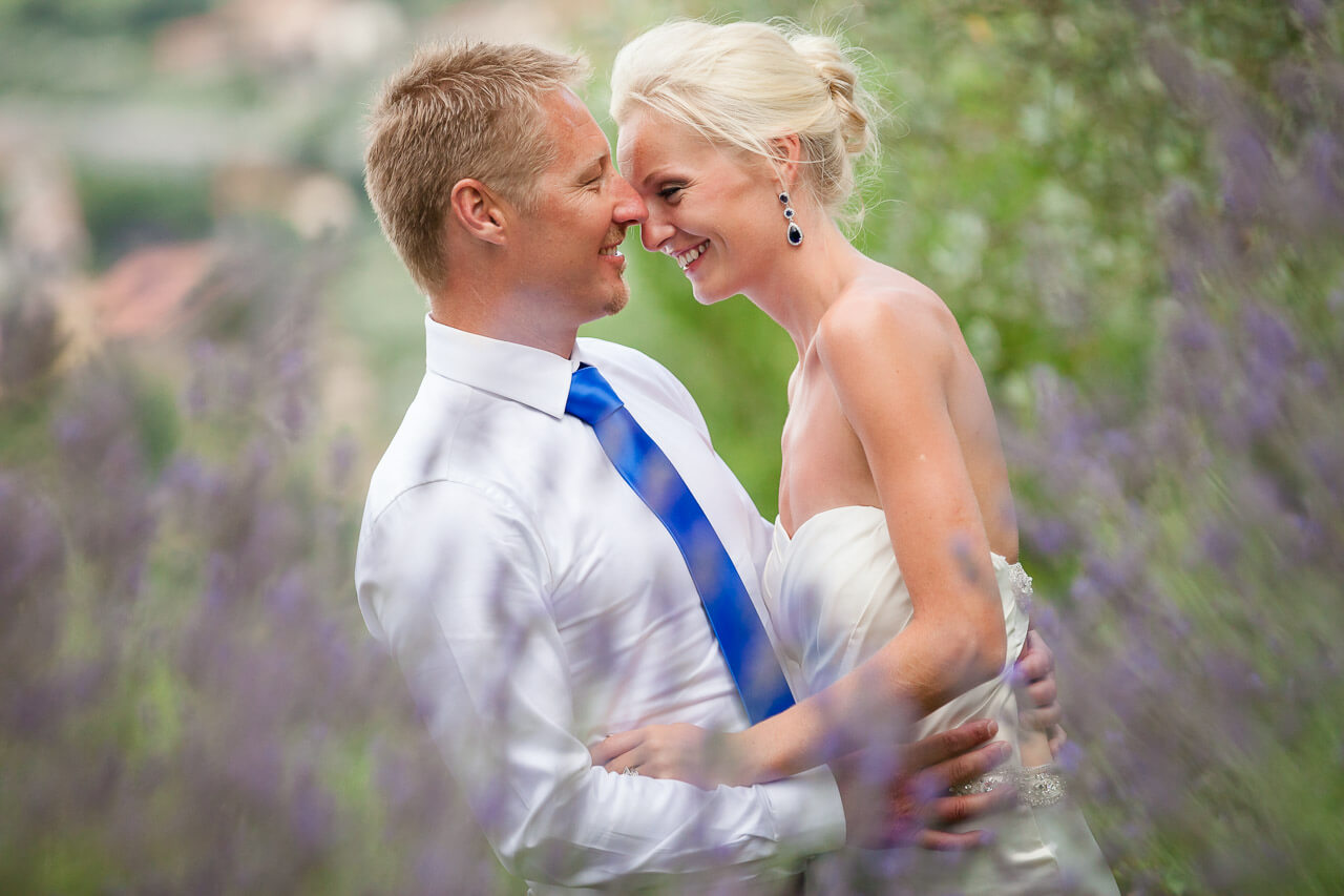 couple standing in among lavender field holding each other looking at each other