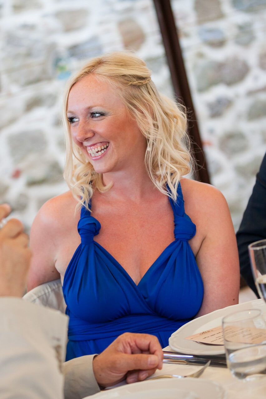 bridesmaid in blue laughing at speech
