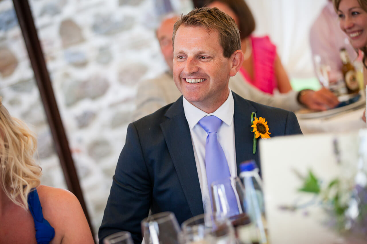 man in suit smiling at speech
