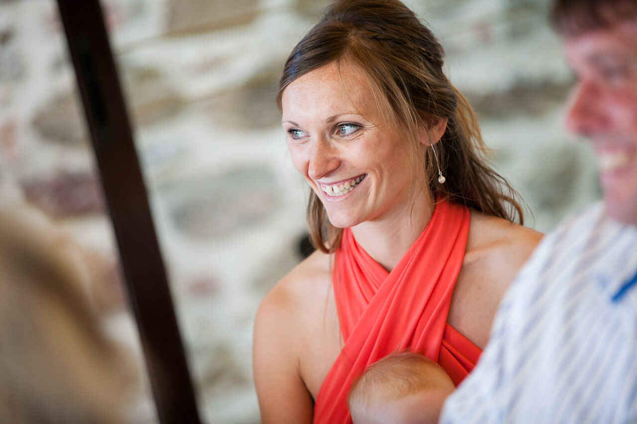 bridesmaid in red smiling while listening to speeches