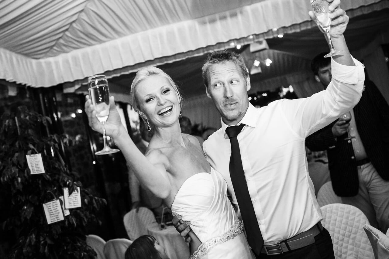 couple raise a glass after cutting the cake
