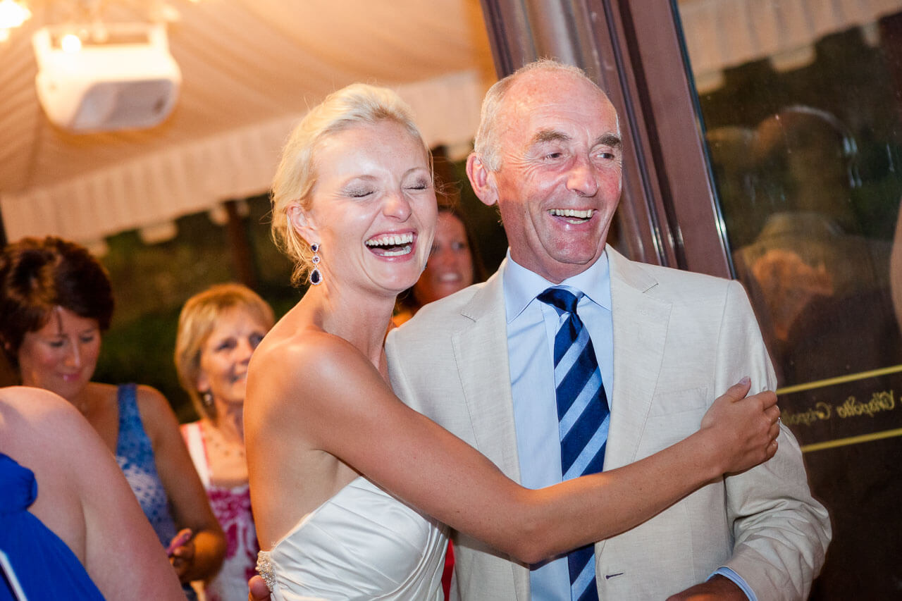 bride and father laughing while bride has her arm wrapped around him