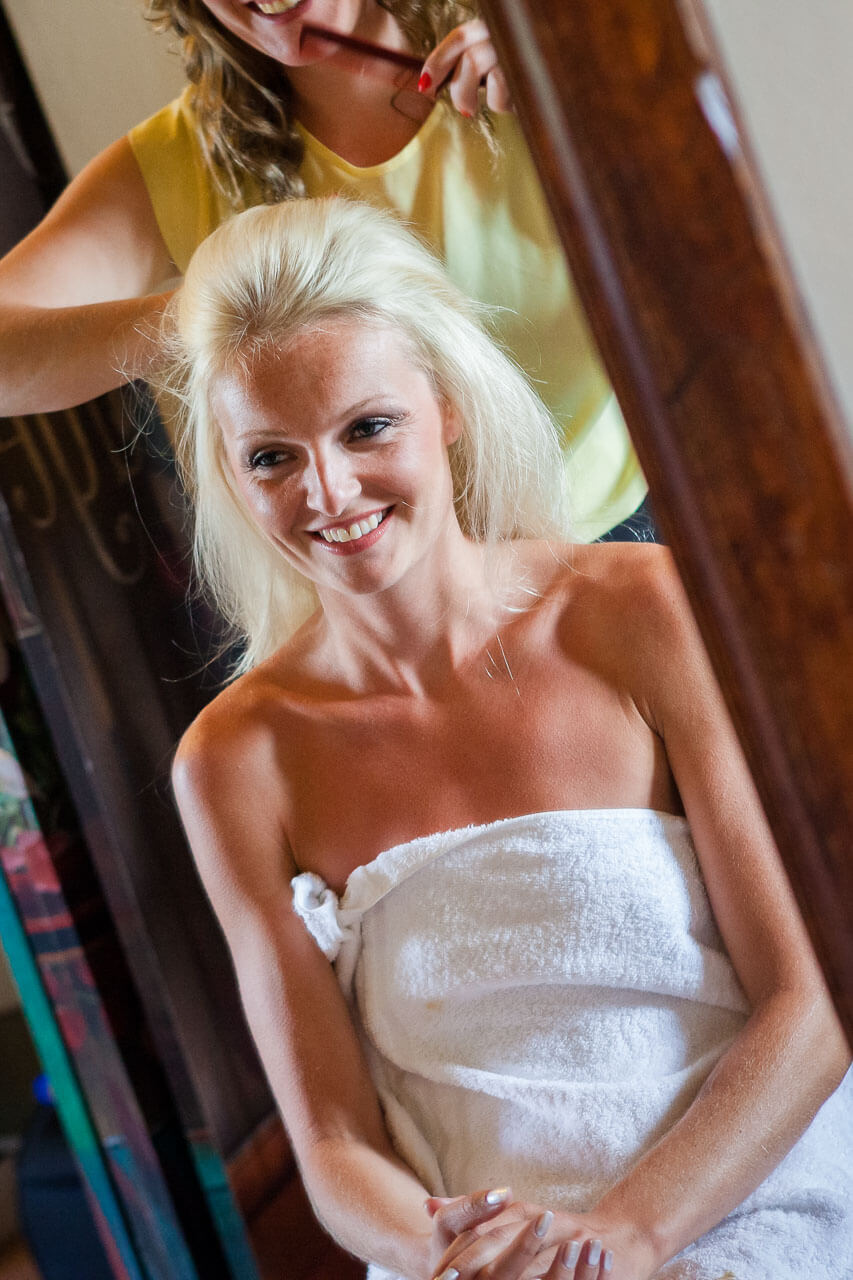 bride getting ready smiling into mirror