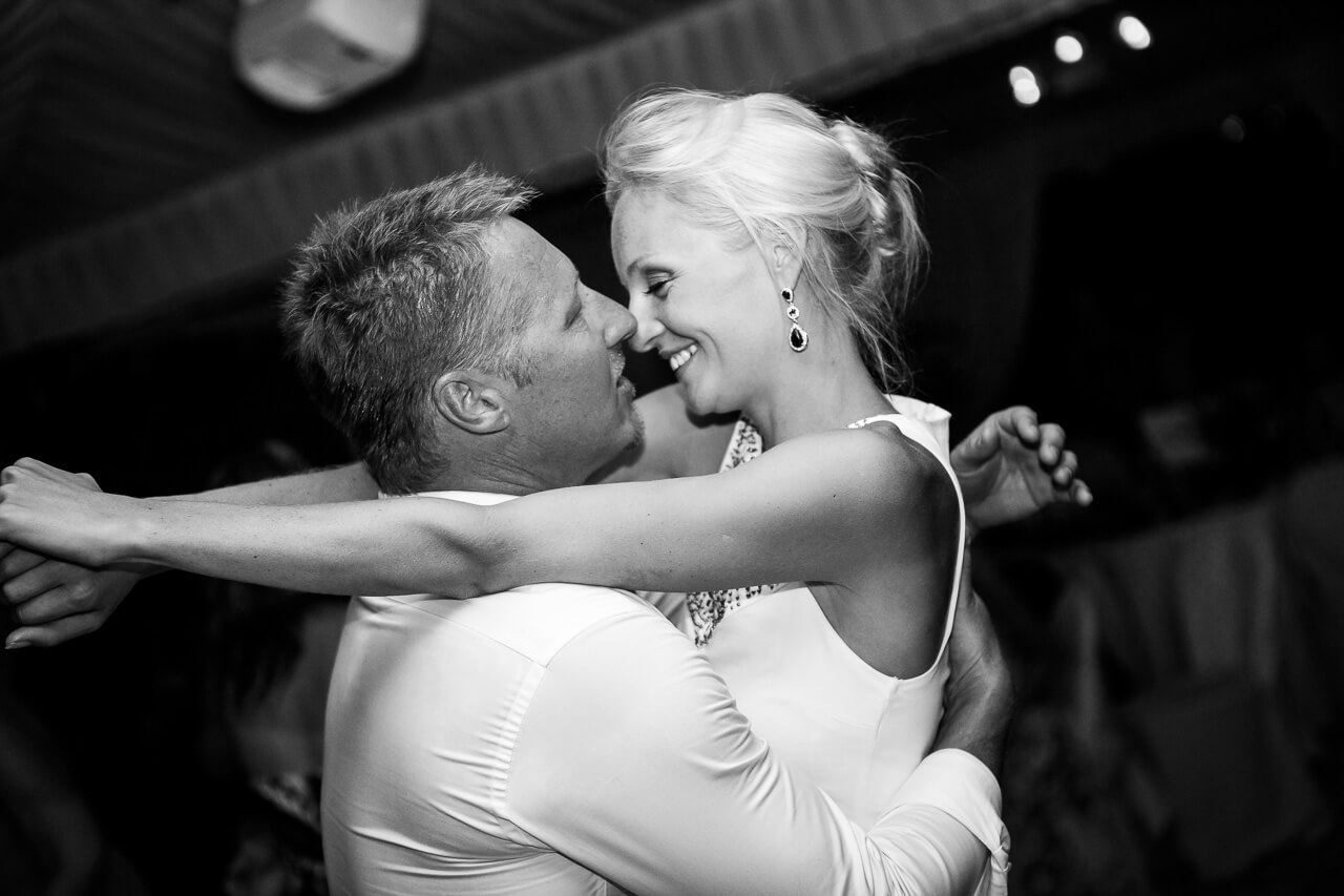 bride and groom with arms around each other as they dance