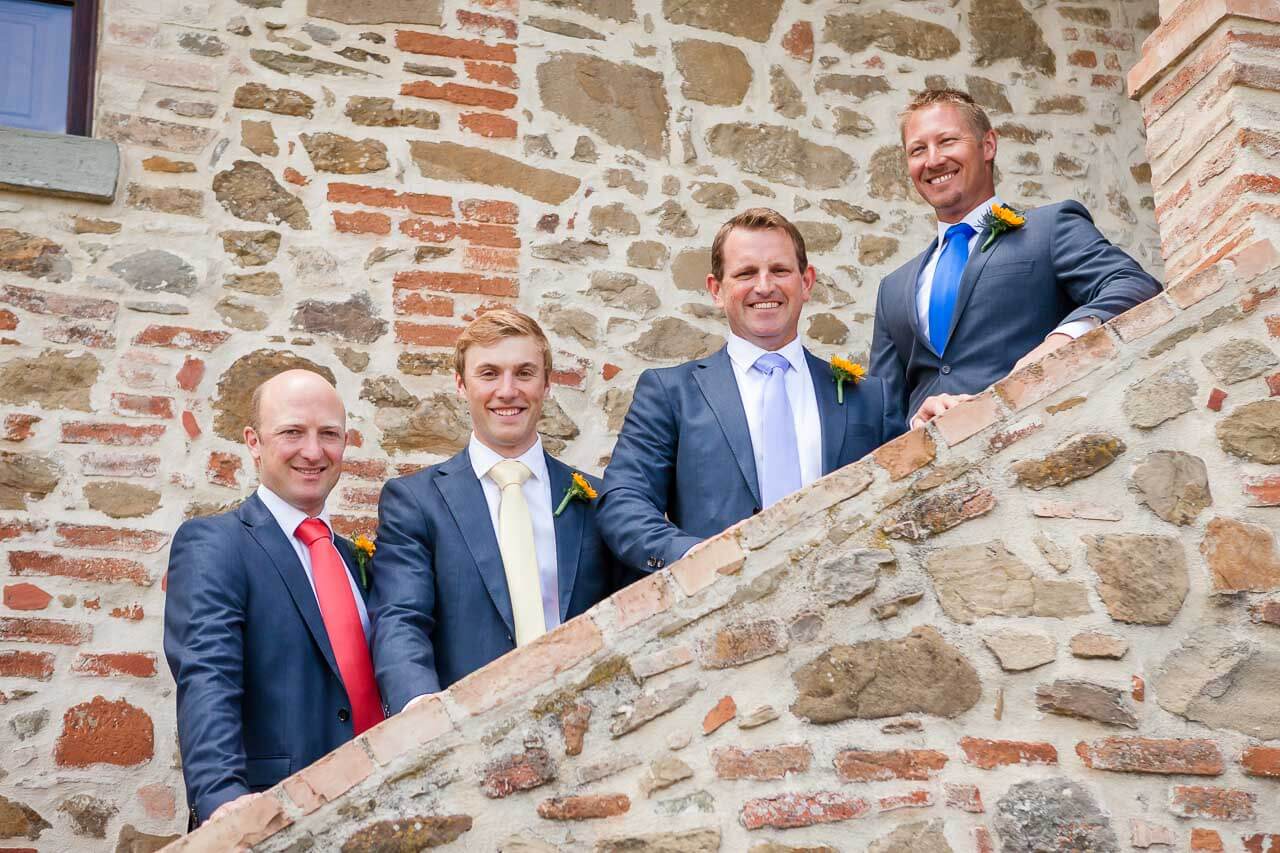 four groomsmen lining up stairs looking at camera