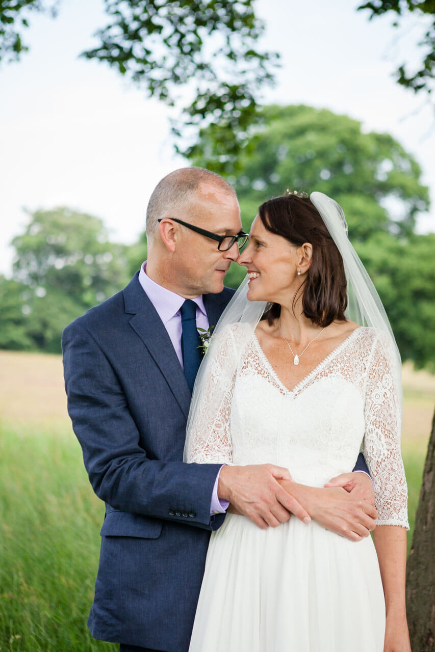 bride and groom touch noses in intimate couple portrait