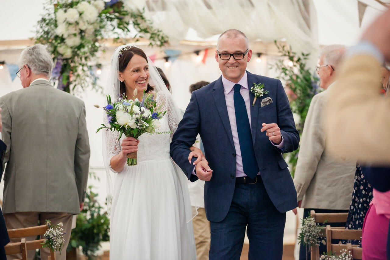 bride and groom walk back down aisle doing a dance