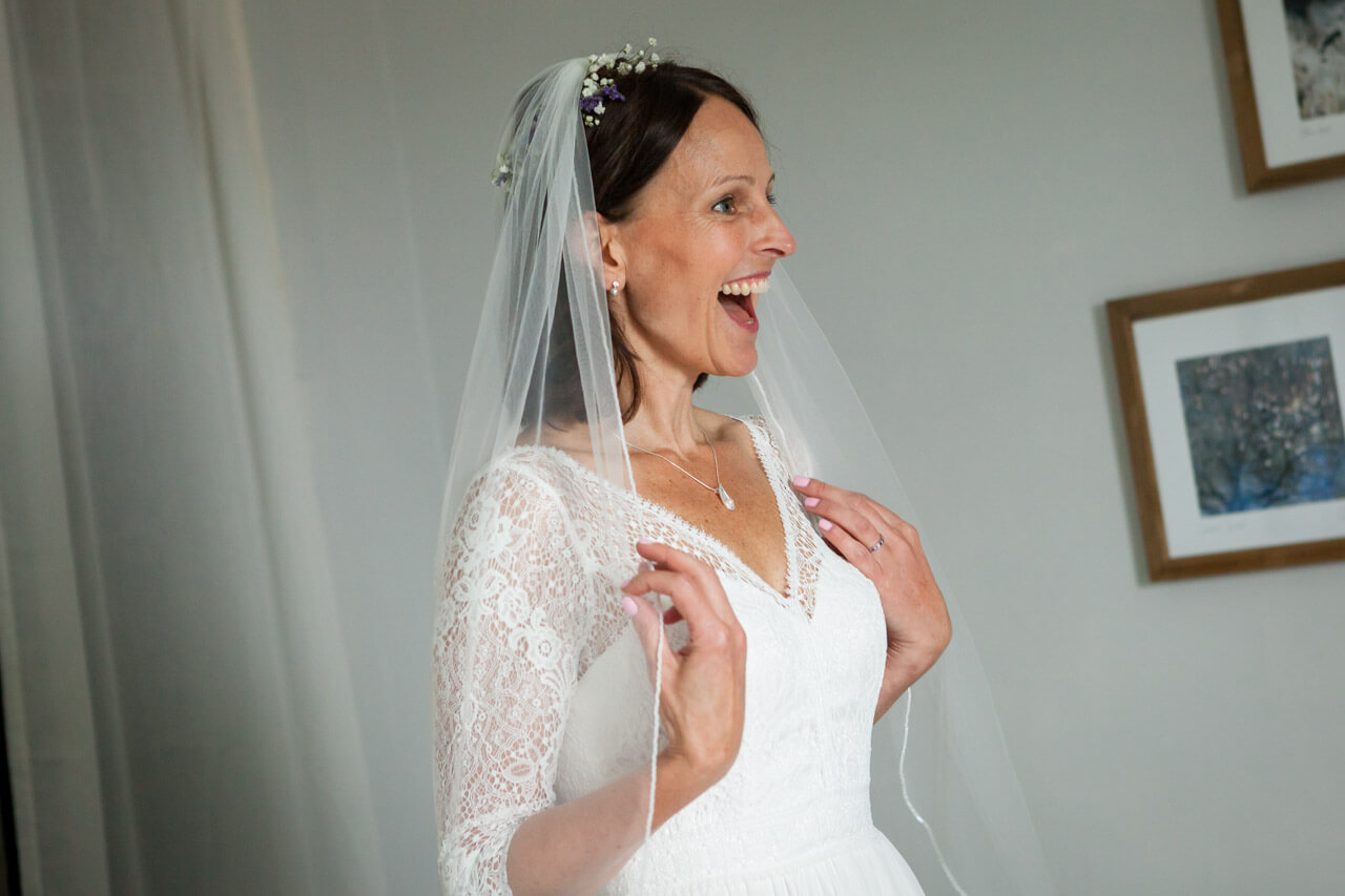 bride looking in mirror for first time smiling