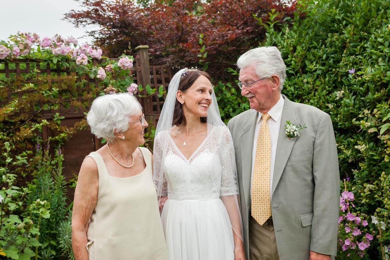 bride and her parents smiling and looking at each other