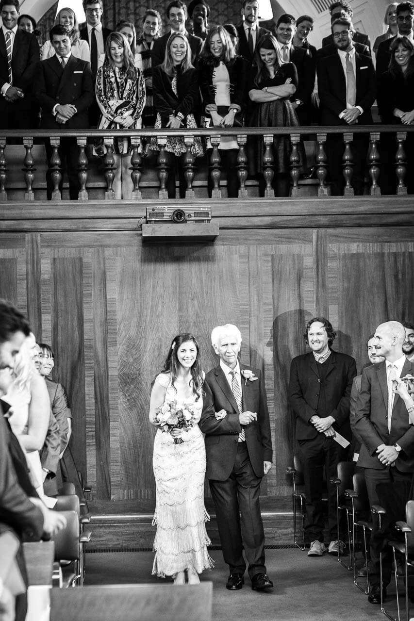 bride walking into town hall with her father
