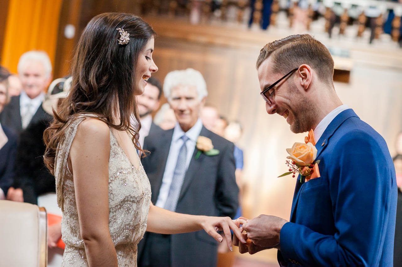 bride and groom putting rings on