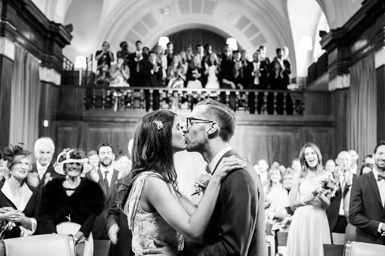 bride and groom kiss in front of guests