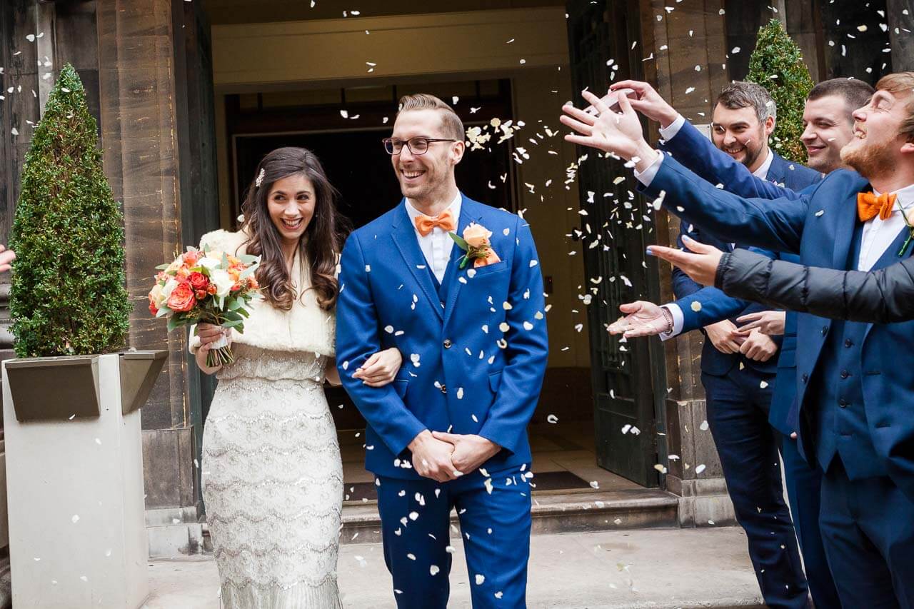 bride and groom walk into confetti