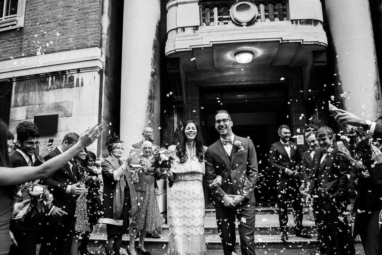bride and groom walking into confetti