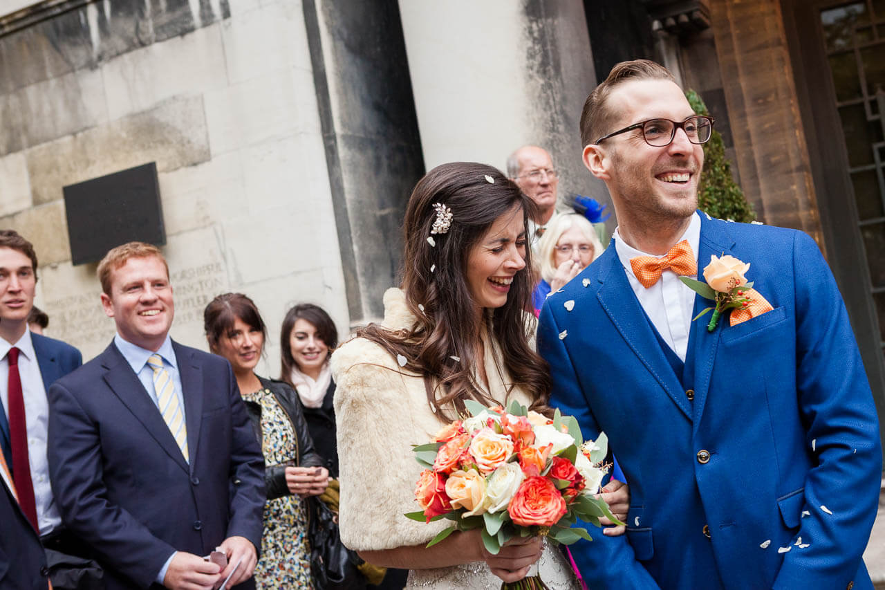 bride and groom stand outside town hall