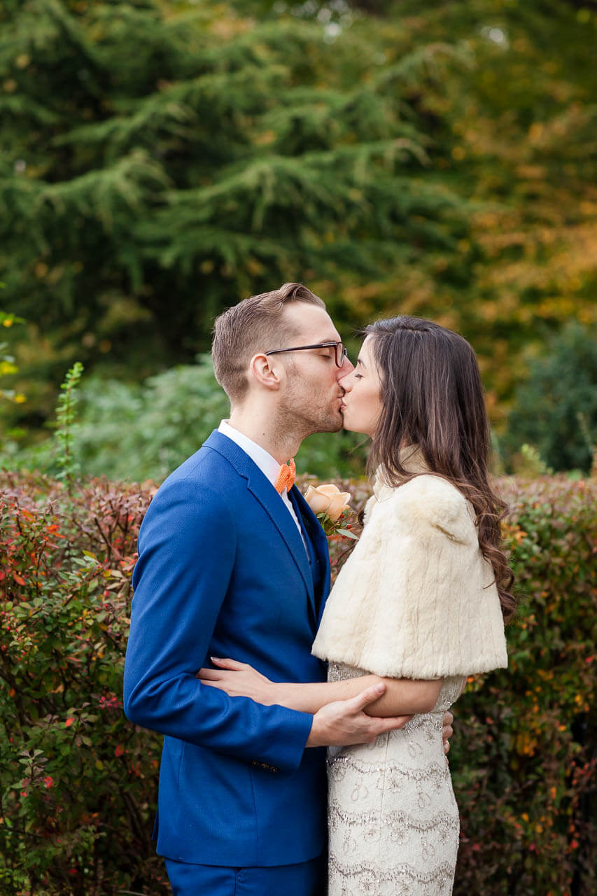 bride and groom kiss in park