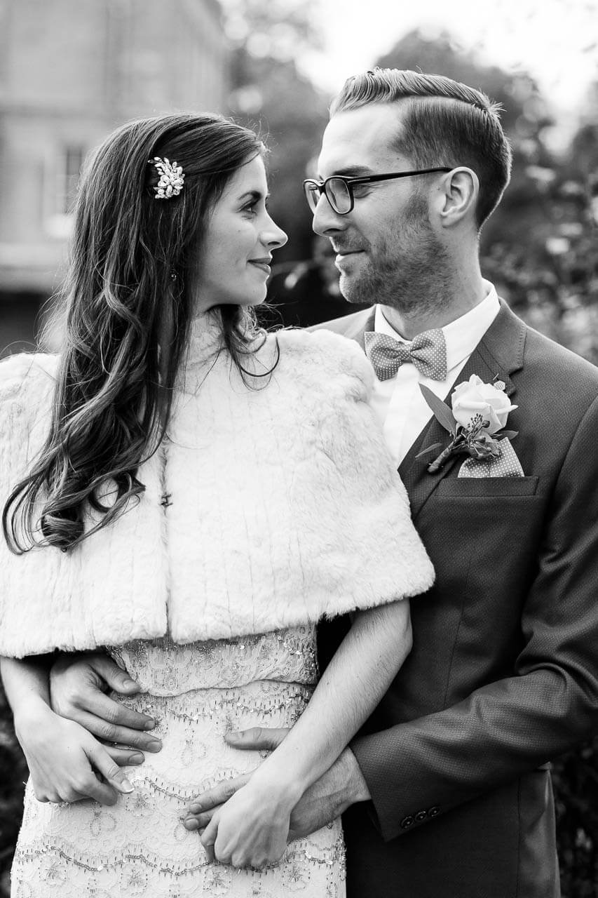 bride and groom look at each other smiling