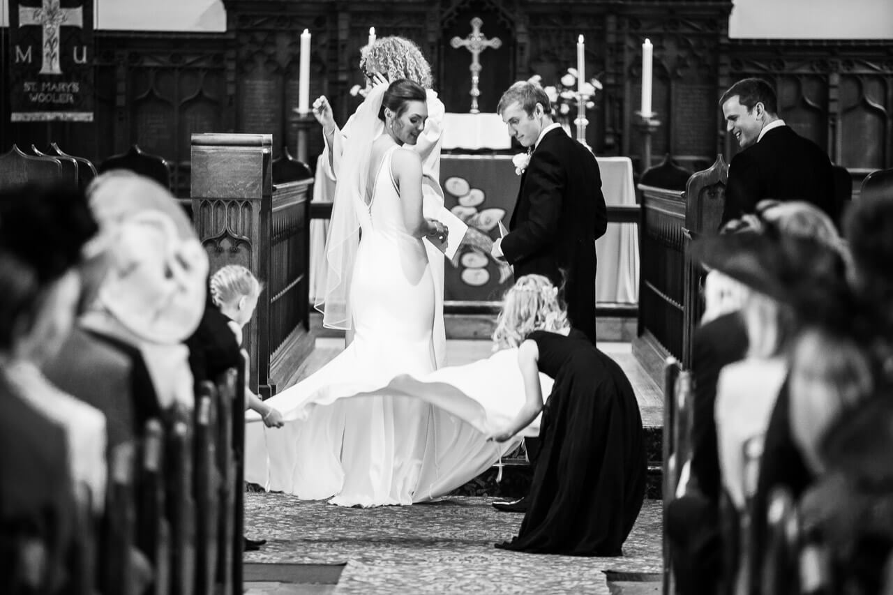 flower girls straightening bride's dress
