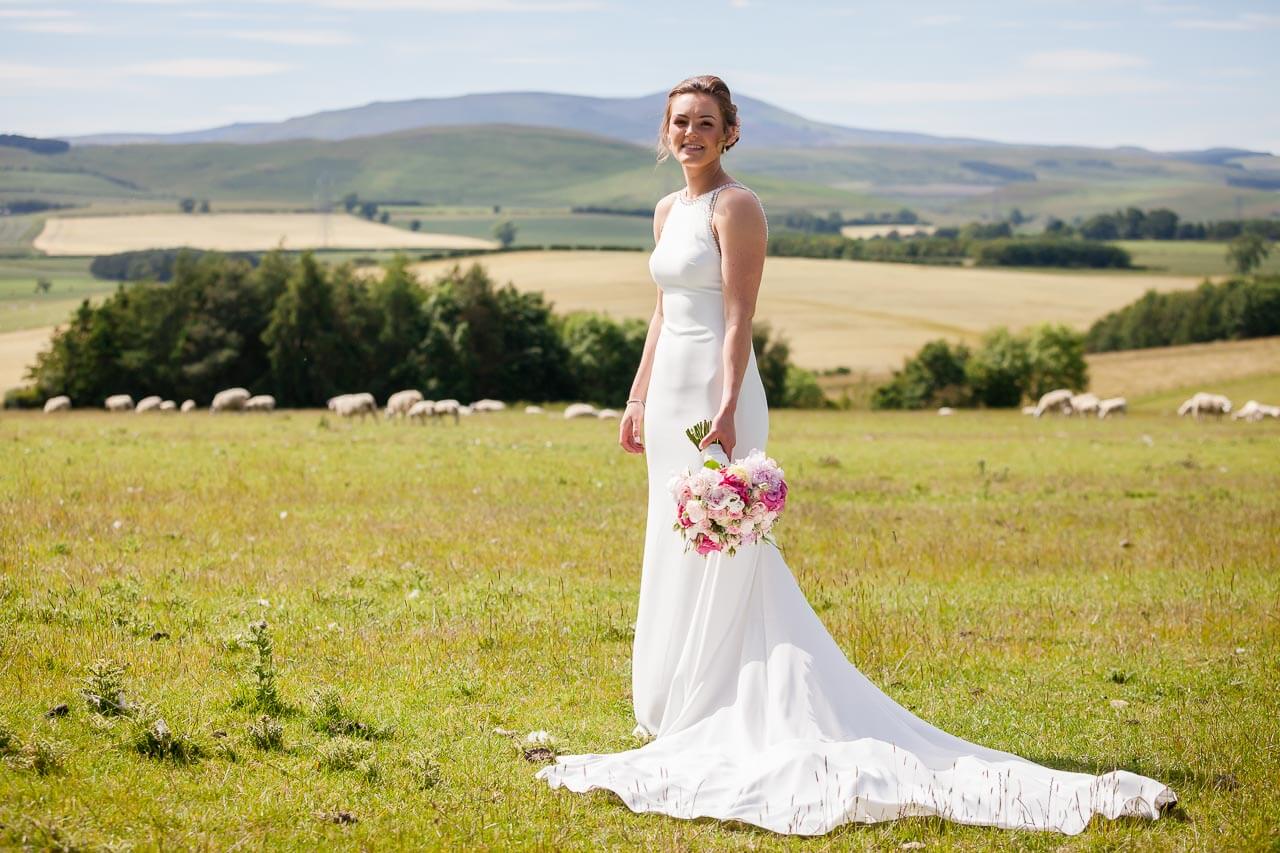 bride looking at camera with fields behind her