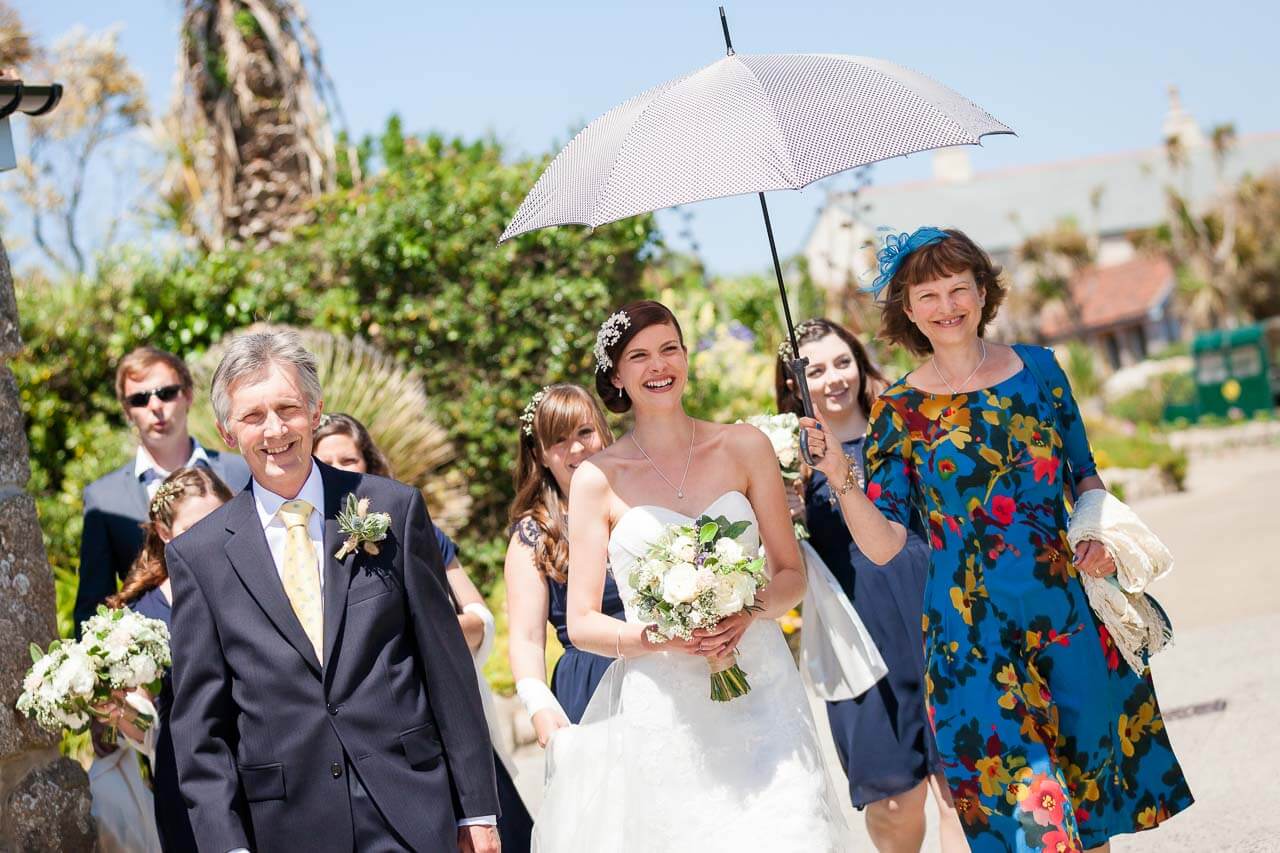 bride and parents walking to the church
