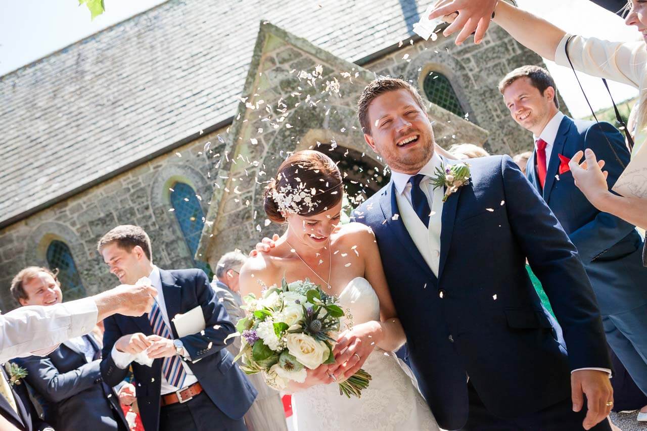 bride and groom walking into confetti