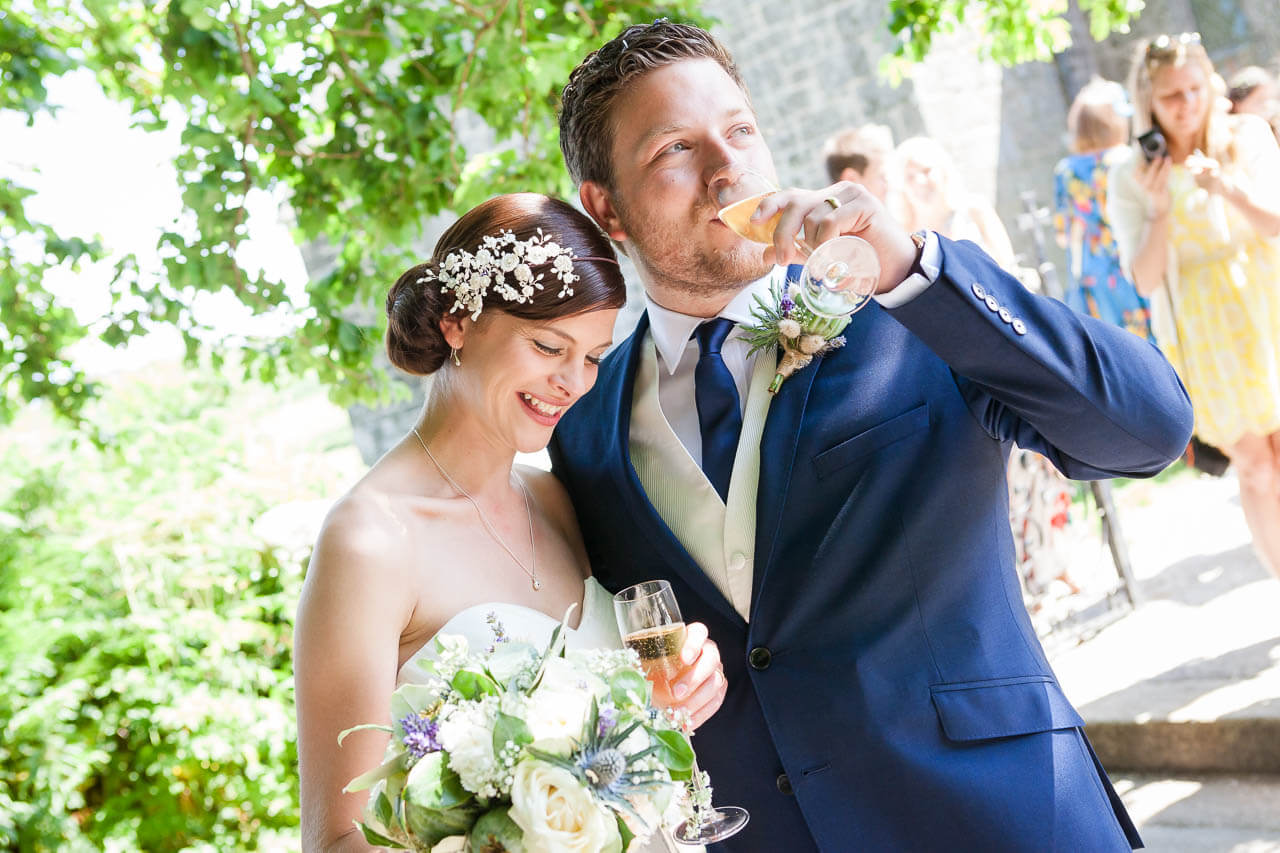 bride and groom drinking champagne