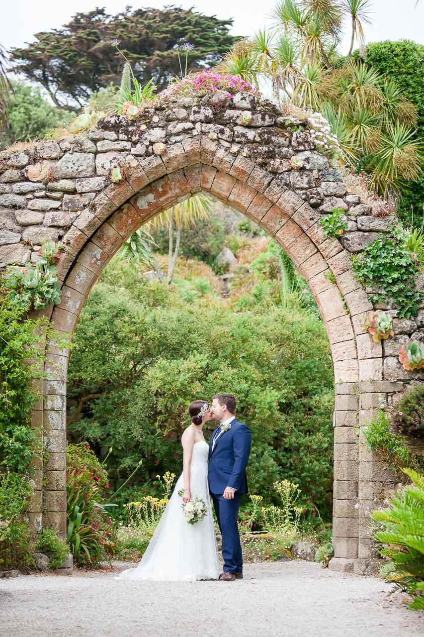 couple kissing under old stone archway