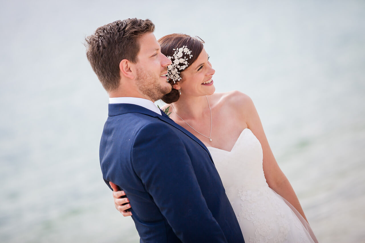 bride and groom smiling on beach