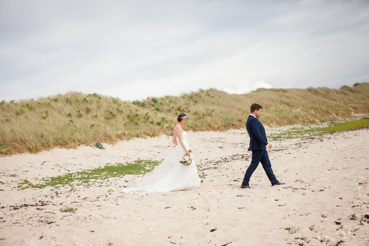 bride and groom walking on beach
