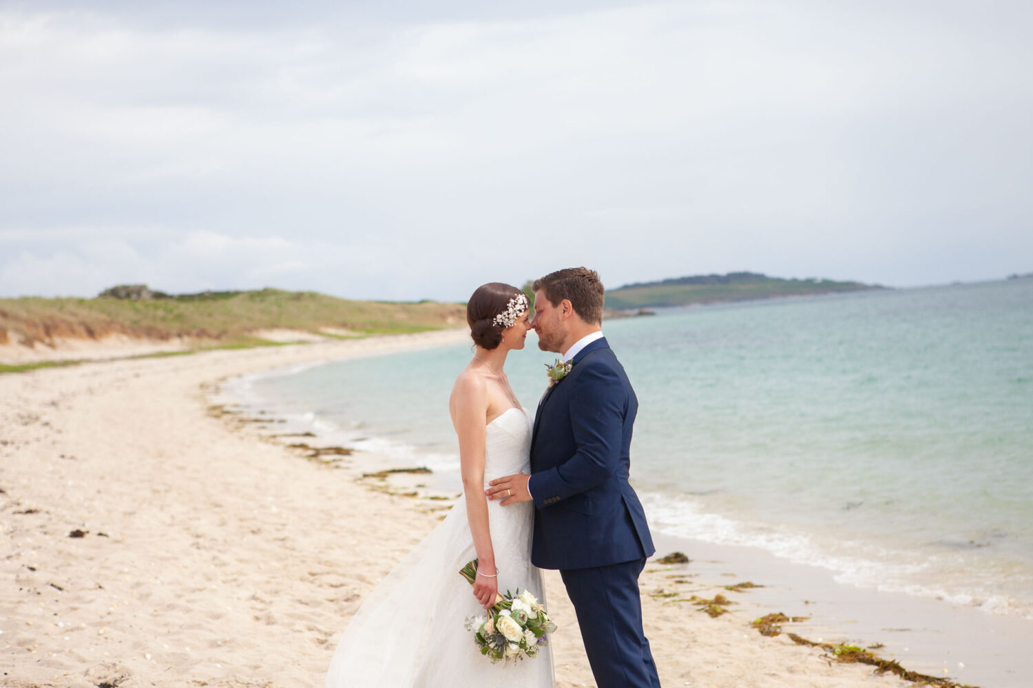 bride and groom forehead to forehead on beach